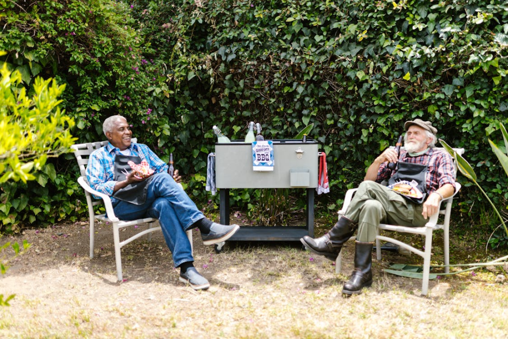 An image of two elderly men sitting together, having beers