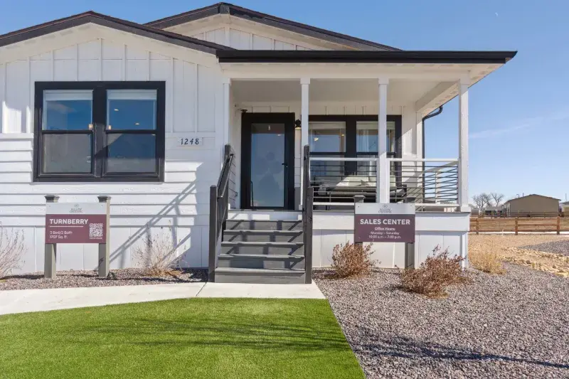 White modular home in Colorado, with a front porch, entry steps, and a clean exterior design